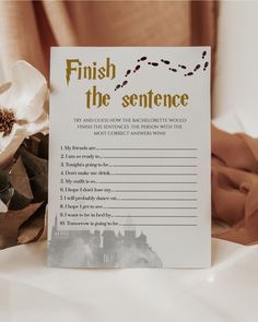 a sign that says finish the sentence next to some flowers on a white table cloth