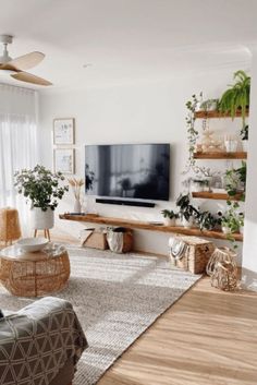 a living room filled with furniture and a flat screen tv on top of a wooden shelf