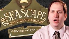 a man wearing a tie standing in front of a sign that says the seascape restaurant & taproom