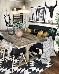 a living room with black and white rugs, wooden table and cow head on the wall