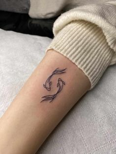 a woman's arm with a fish tattoo on it