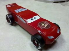 a red toy car sitting on top of a white floor