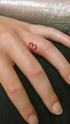 a woman's hand with a heart tattoo on it