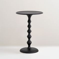 a black table with an intricate design on the top and bottom, against a white background