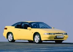 a yellow car is parked on the pavement