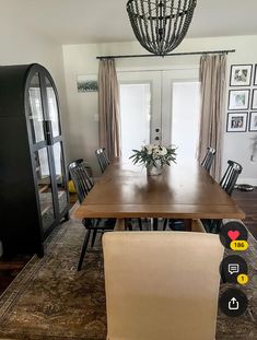 a dining room table with chairs and pictures on the wall