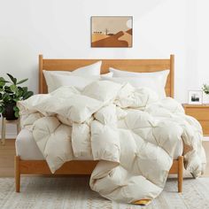 an unmade bed with white comforter and pillows on it in a bedroom setting