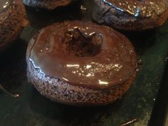 chocolate doughnuts sitting on top of a baking sheet