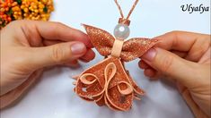 two hands are holding an ornament made out of copper glitters and pearls