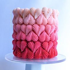 a pink and red cake sitting on top of a table