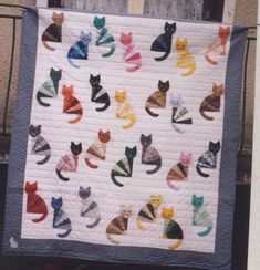 there is a quilt with many cats on it