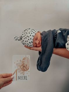 a baby is being held up by someone's hand with a name tag on it