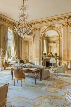 an ornate living room with chandelier and chairs