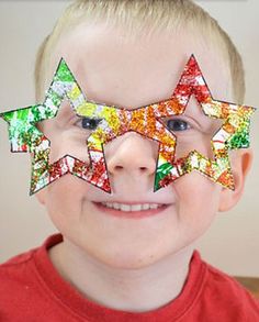 a young boy is smiling and wearing colorful stars on his face