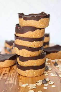 chocolate covered cookies stacked on top of each other with oatmeal scattered around them