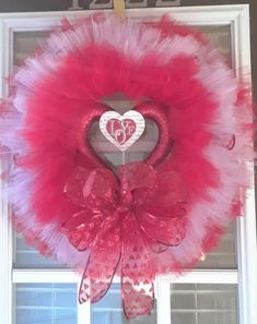 a valentine's day heart wreath hanging on a window sill in front of a door