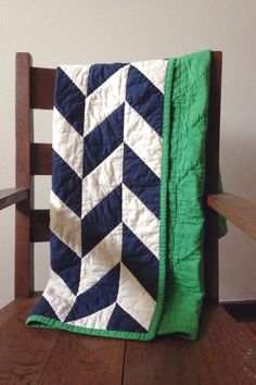 a wooden chair with a green and white quilt on it