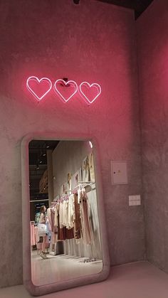 there is a mirror that has hearts on it in front of a wall with clothes