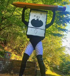 a man dressed as a cartoon character holding a surfboard on his head