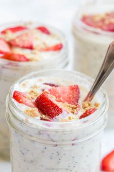 two mason jars filled with overnight oatmeal and topped with fresh strawberries