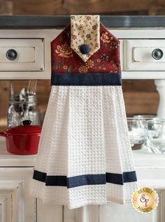 a white dress hanging from a hook in a kitchen