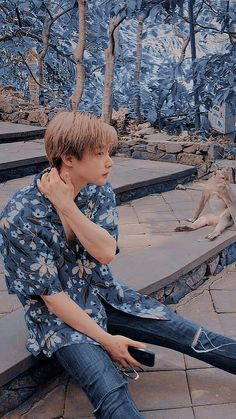 a young man sitting on the ground next to a kangaroo