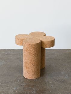 three cork tables sitting on top of a cement floor