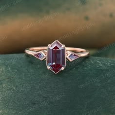 a pink tourmaline ring on top of a green surface