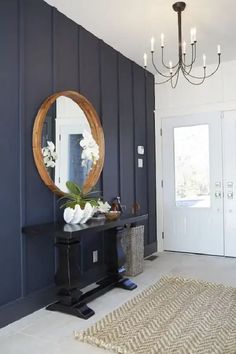 a room with blue walls and a mirror on the wall next to a black table