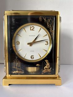 a gold and black clock sitting on top of a table