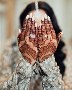 a woman is holding her hands up to show the hendi