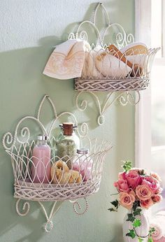 two metal baskets filled with bath items on top of a shelf next to a window