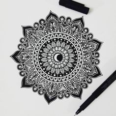 a black and white drawing of a flower with an eye in the center, surrounded by sharpie markers