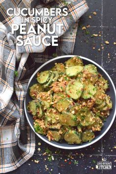 cucumbers and spicy peanut sauce in a white bowl on a black tablecloth