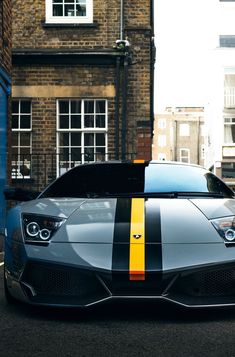 a silver sports car with black and yellow stripes