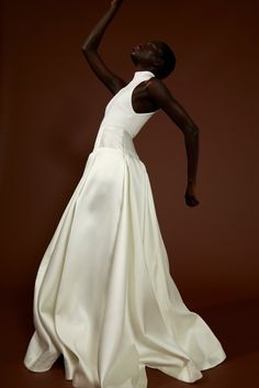 a woman in a white dress is dancing