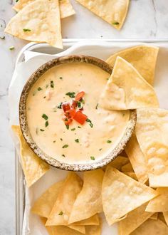 tortilla chips and dip in a bowl on a plate