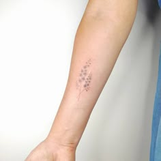 a woman's arm with a small tattoo on the left side of her arm