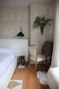 a white bed sitting next to a wooden floor