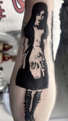 a woman's arm with a black and white tattoo design on her left arm