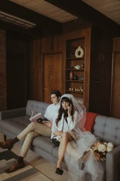 a bride and groom sitting on a couch