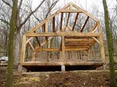 a wooden structure sitting in the middle of a forest