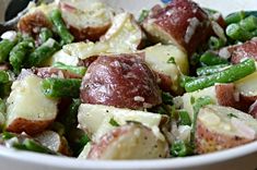 a white bowl filled with potatoes and green beans