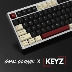 a computer keyboard sitting on top of a black and white background with the words gmk clone x keyz