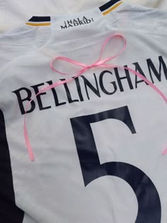 a white shirt with the number five tied to it's chest and name on it