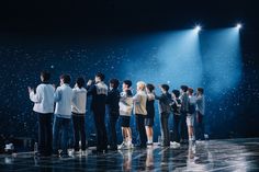 a group of people standing on top of a stage with spotlights in the background