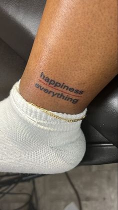 someone with a tattoo on their leg saying happiness is everything