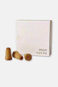 three pieces of bread sitting next to each other in front of a white box with the word palo sano written on it