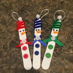 three snowmen made out of toothbrushes sitting on top of a counter