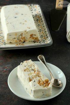 a piece of cake sitting on top of a white plate next to a silver spoon